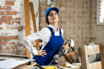 Wall Mural - Woman contractor with industrial puncher at construction site