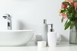 Vase with beautiful Alstroemeria flowers and toiletries near sink in bathroom