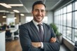 © Marco Mamdouh - Portrait of happy businessman with arms crossed standing in office