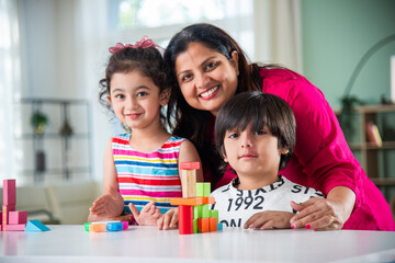 Indian Day care concept showing kids playing with toys with woman