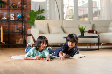 Cute little Indian asian boy child kid preschooler playing with blue car toy