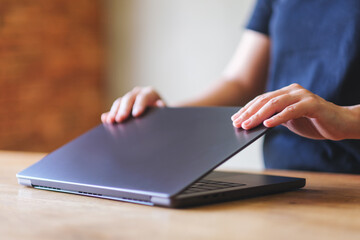 Wall Mural - A woman opening or closing laptop computer, getting ready for work