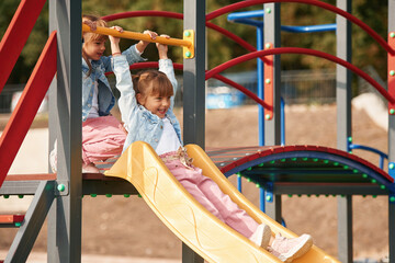 On a playground slide. Little girl is having fun on