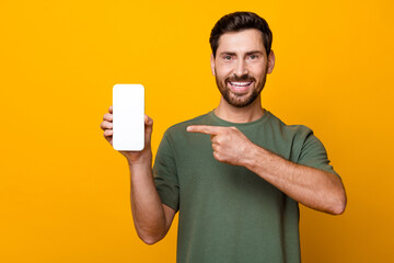 Poster - Photo portrait of attractive young man hold device point white screen dressed stylish khaki clothes isolated on yellow color background