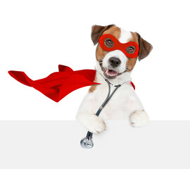 Sticker - jack russell terrier wearing like a doctor with superhero cape and with stethoscope on his neck looks above empty white banner. Isolated on white background