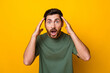 Photo of impressed funky man wear khaki t-shirt arms head open mouth isolated yellow color background
