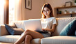 © anmitsu - Beautiful young Asian female freelancer is sitting on a comfortable sofa and browsing the internet on a laptop to successfully conduct business. Luxurious interior. Work from home concept.