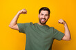 © deagreez - Photo portrait of attractive young man excited hands show muscles dressed stylish khaki clothes isolated on yellow color background