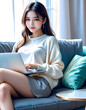 © anmitsu - Beautiful young Asian female freelancer is sitting on a comfortable sofa and browsing the internet on a laptop to successfully conduct business. Luxurious interior. Work from home concept.