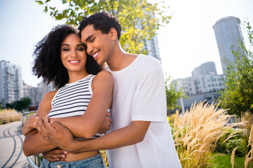 Poster - Photo of charming loving couple guy husband cuddle wife enjoy buying new flat in modern cityscape