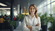 © DigitalDreamscape - Successful young businesswoman with arms crossed standing in a modern business building - pretty smiling confident woman with long hair