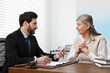 © New Africa - Senior woman having meeting with lawyer in office