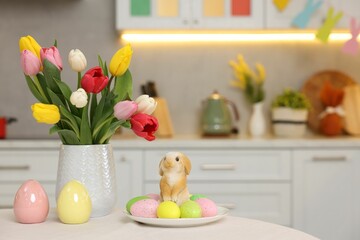 Sticker - Bouquet of tulips, painted eggs and Easter decorations on white table in kitchen. Space for text