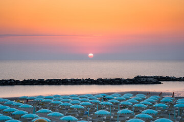 Wall Mural - Beautiful sunrise on Rimini beach with umbrellas