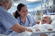 Smiling nurse checking senior patient who is recovering at hospital