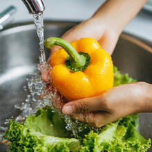 Close Up Hand Of Asian Young Housekeeper Woman, Washing Sweet Pepper, Yellow Paprika, Vegetables With Splash Water In Basin Of Water On Sink In Kitchen, Preparing Fresh Salad, Cooking Meal.Health Food