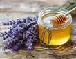 Honey jar with honey dipper, stick and lavender flowers on wooden table with copy space. Beekeeping, natural treatment for cough, strengthening the immune system and preventing colds concept