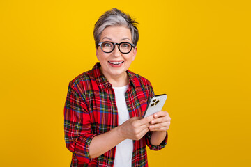 Wall Mural - Portrait of cheerful impressed person hold smart phone empty space ad isolated on yellow color background