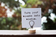 © cn0ra - Paper note with inspirational quotes turn your wounds into wisdom
