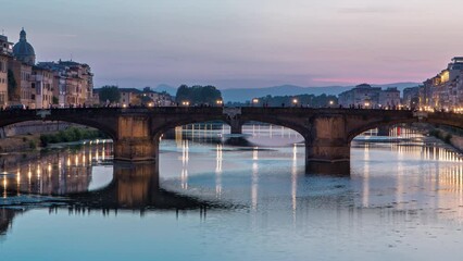 Canvas Print - Twilight scene of Ponte Santa Trinita (Holy Trinity Bridge) day to night transition timelapse over River Arno with reflections on water after sunset. Florence, Tuscany, Italy