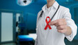 © New Africa - Cancer awareness. Doctor holding red ribbon on blurred background, closeup. Banner design with space for text