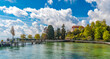 Large panorama of the pier on the east side of Mainau Island, the famous island in Lake Constance (Bodensee). Visitors are walking on the landing stage towards the entrance of the tourist attraction.