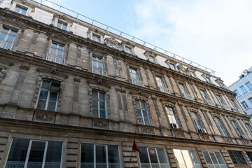 Wall Mural - A large building with many windows and a red flag on the roof