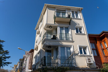 Wall Mural - A large white building with balconies and a blue sky in the background