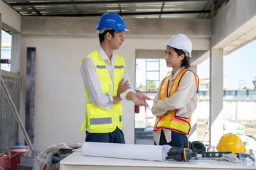 Wall Mural - Civil engineer teams meeting working together wear worker helmets hardhat on construction site in modern city. Foreman industry project manager engineer teamwork. Asian industry professional team