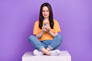 Sticker - Photo of brunette business woman sitting podium optimizing her job using smartphone and technologies isolated on violet color background