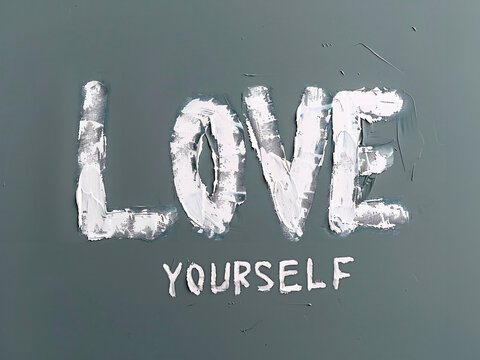 LOVE YOURSELF text written by hand with white paint. Minimalistic lettering isolated on a dark gray background