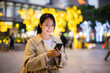 Woman hold with smart phone in Taipei city at evening time