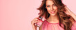 © MK studio - beautiful young girl with a bottle of perfume in her hands on a pink background. advertising poster or banner. space for text