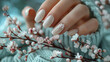 Eleganz bis in die Fingerspitzen: Zarte Hand mit stilvollem Maniküre-Design und Frühlingsblumen