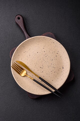 Cutlery fork, knife and spoon on a dark textured concrete background