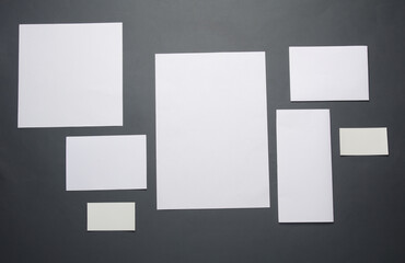 Mockup for design of white blank sheets of paper of different sizes and shapes, cards on dark gray background. Corporate identification. Creative layout