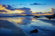 Les nuages se reflètent sur le sable mouillé à marée basse, une scène captivante sur une plage de la Presqu'île de Crozon en Bretagne, fusionnant ciel et terre dans une harmonie paisible.