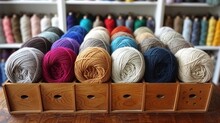 Several Skeins Of Yarn Sit In A Wooden Box On A Table In Front Of A Rack Of Other Skeins.