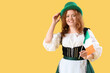 © Pixel-Shot - Young Irish waitress with flag on yellow background. St. Patrick's Day celebration
