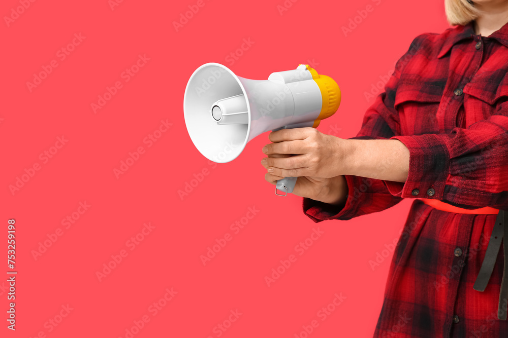Mature woman with megaphone on red background