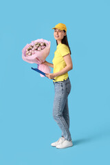 Poster - Young delivery woman with bouquet of beautiful roses and clipboard on blue background