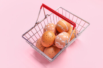 Poster - Shopping basket with Easter eggs on pink background