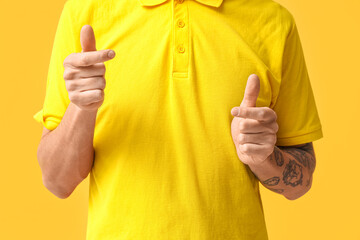 Wall Mural - Young deaf mute man using sign language on yellow background