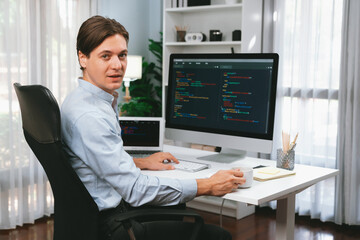 IT developer looking camera with online software development information on pc and laptop monitor beside, coding program on updated version application project creating new code system. Pecuniary.