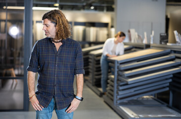 Confident man picking new bathroom wall furnishing materials in hardware store