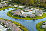 Fototapeta Mapy - View from above of residential houses in living area in North Port, FL. American dream homes as example of real estate development in US suburbs