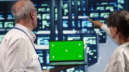 Poster - meticulous experts looking around high tech data center, using mockup laptop to crosscheck disaster 