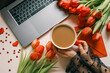 Cup of coffee, bouquet of red tulips and cake top view flat lay, festive background