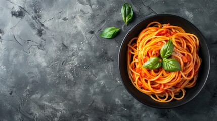 Wall Mural - Pasta, spaghetti with tomato sauce in black bowl on grey background. Copy space. Top view.