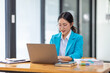© David - Portrait of asian young female entrepreneur sitting at her desk in the office